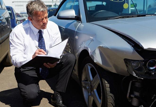 broken windshield with auto insurance paperwork